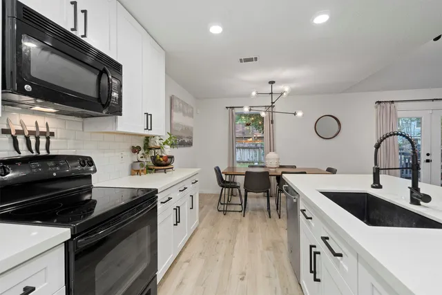 a kitchen with a sink stainless steel appliances and cabinets