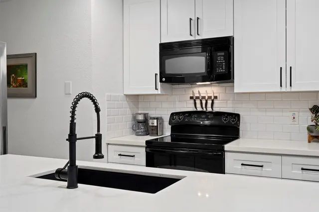 a kitchen with stainless steel appliances a stove microwave and sink