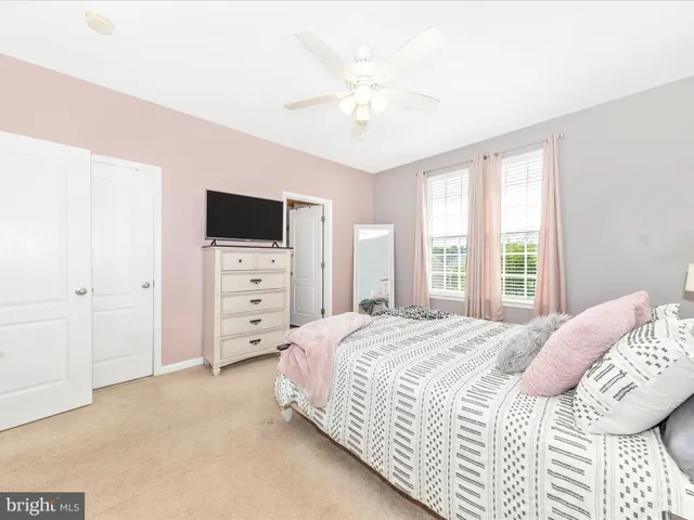 a bedroom with a bed a chandelier and a flat screen tv