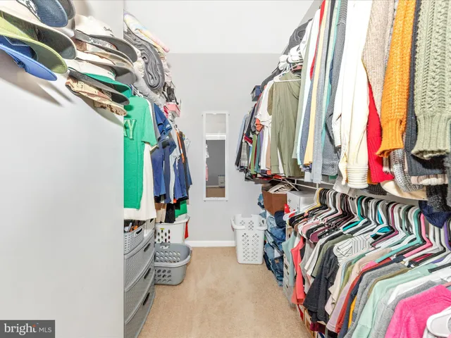 a view of walk in closet with clothes and shoes