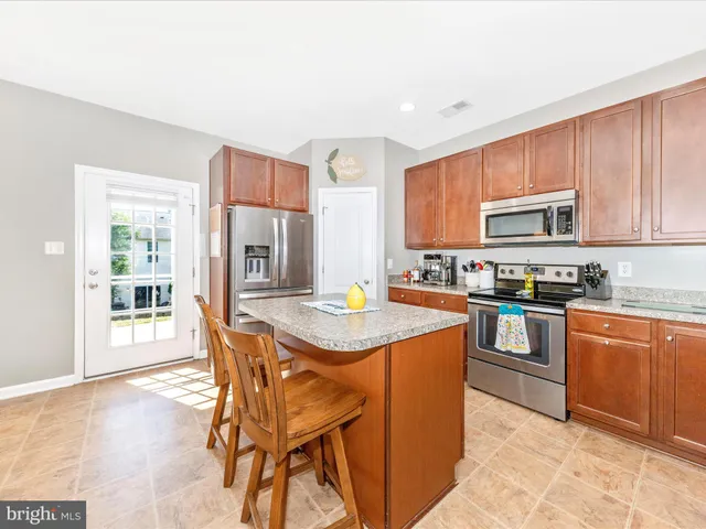 a kitchen with stainless steel appliances granite countertop a stove top oven a sink dishwasher and a microwave oven on the blue kitchen countertops