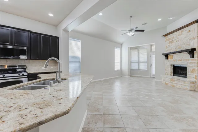 a kitchen with stainless steel appliances granite countertop a stove a sink and a refrigerator