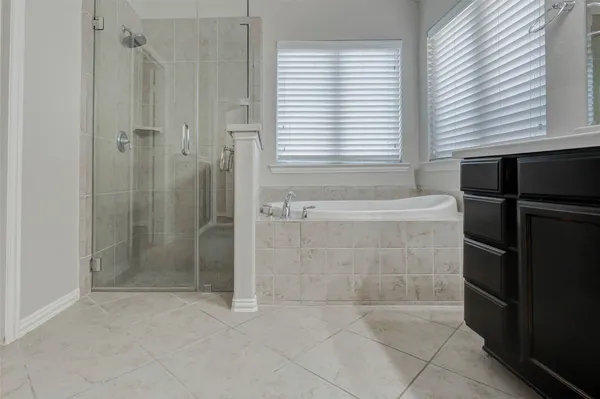 a bathroom with a sink vanity and tub