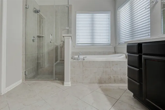 a bathroom with a sink vanity and tub