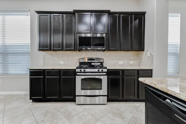a kitchen with granite countertop a sink and a stove
