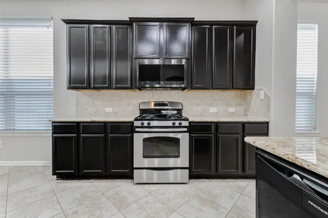 a kitchen with granite countertop a sink and a stove
