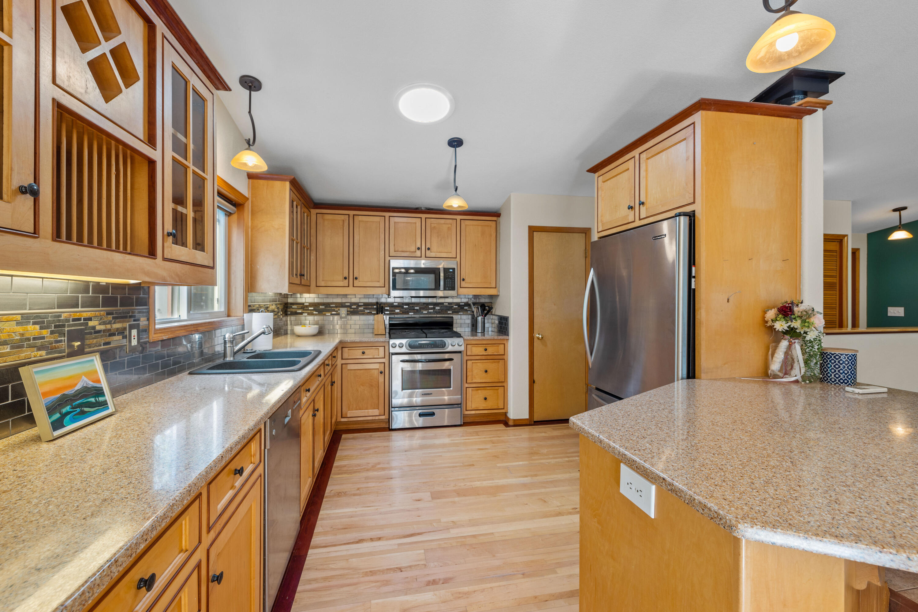 19102 Choctaw Road Bend, OR 97702 - Photo 5 of 14 a kitchen with stainless steel appliances granite countertop a sink a stove and a refrigerator