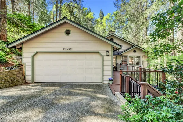 a view of a house with wooden deck and a yard