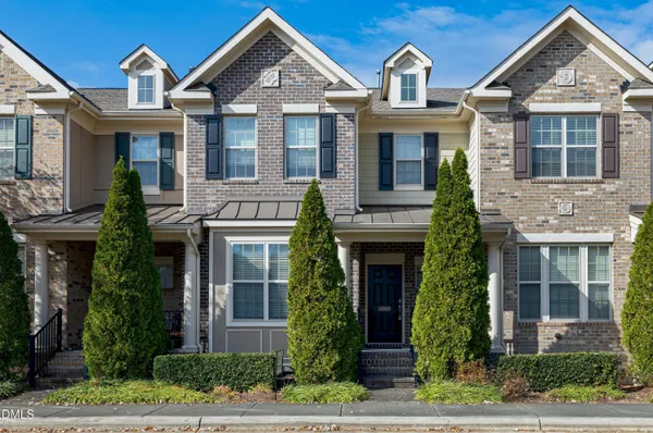 a front view of a house with a garden and plants