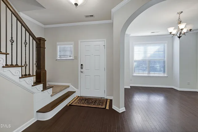 a view of a hallway with wooden floor and stairs