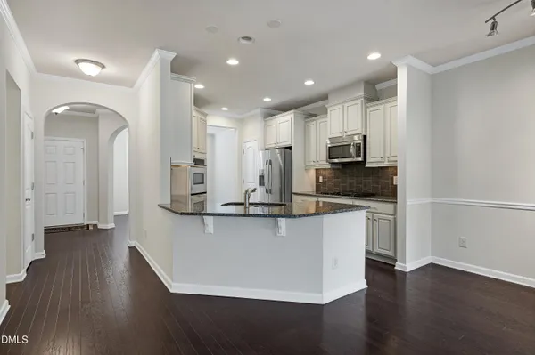 a kitchen with stainless steel appliances granite countertop a refrigerator a microwave and sink