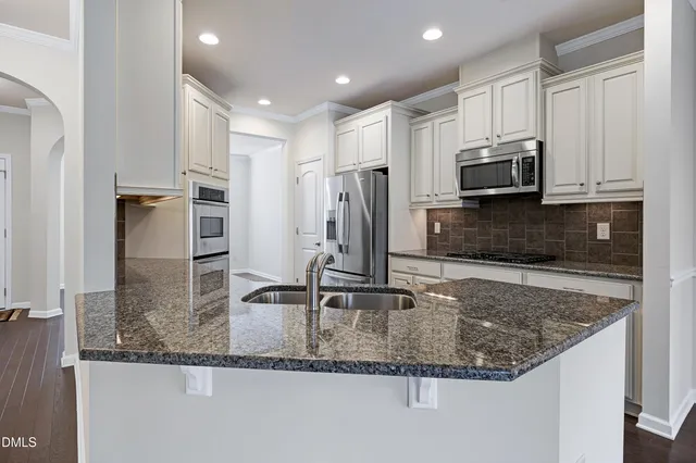 a kitchen with kitchen island white cabinets and stainless steel appliances
