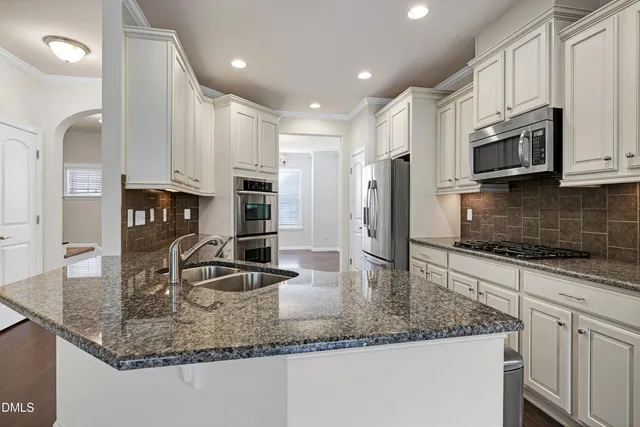 a kitchen with kitchen island a counter top space cabinets and stainless steel appliances