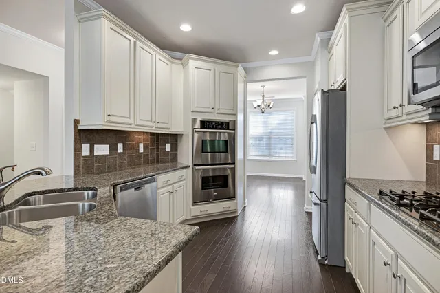 a kitchen with stainless steel appliances granite countertop a sink refrigerator and microwave