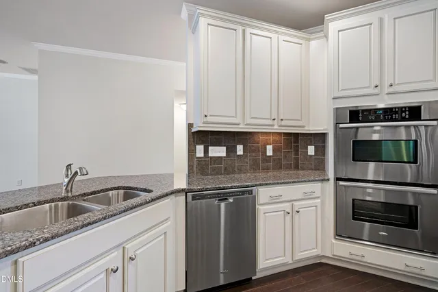 a kitchen with stainless steel appliances granite countertop a sink refrigerator and microwave