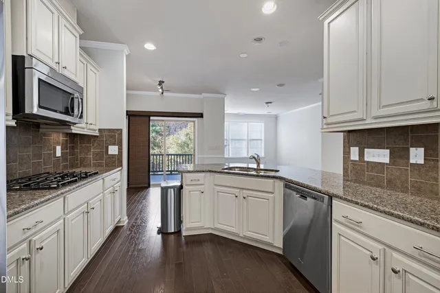 a kitchen with stainless steel appliances granite countertop a stove a sink and a refrigerator