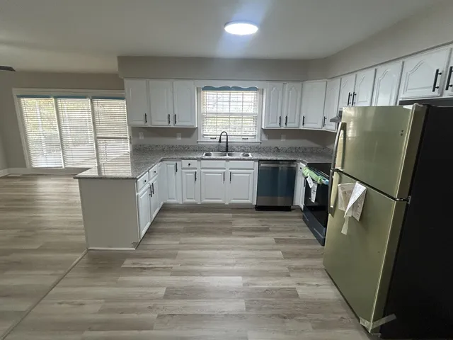 a kitchen with granite countertop a refrigerator sink and microwave