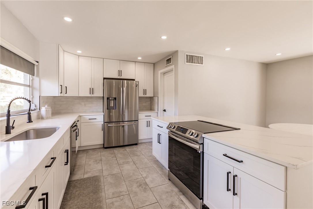 905 Dean Way Fort Myers, FL 33919 - Photo 11 of 43 a kitchen with a sink stove and refrigerator