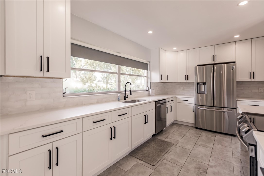 905 Dean Way Fort Myers, FL 33919 - Photo 10 of 43 a kitchen with a refrigerator and a sink