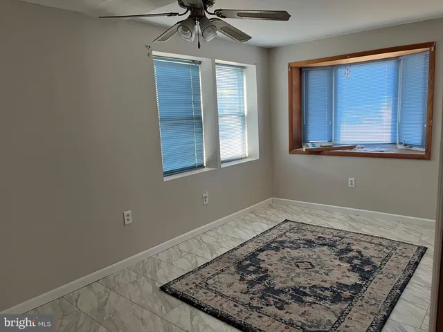 a view of a livingroom with wooden floor and a ceiling fan