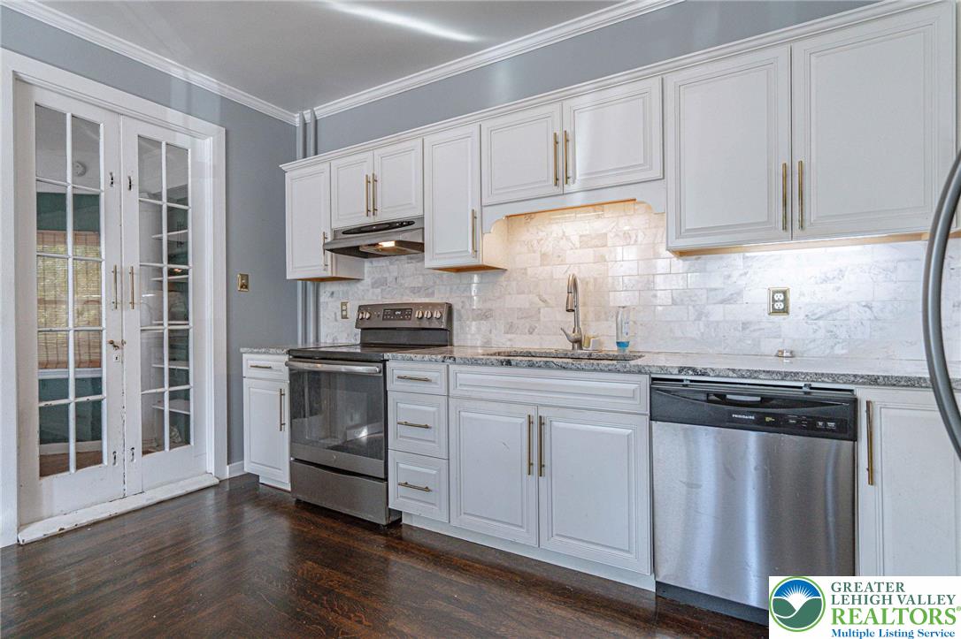 451 East Broad Street Tamaqua, PA 18252 - Photo 23 of 66 a kitchen with stainless steel appliances granite countertop a stove and white cabinets