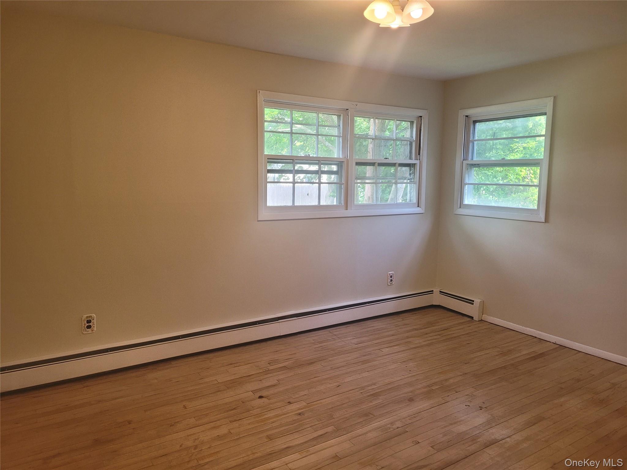 8 Cornell Road East Patchogue, NY 11772 - Photo 15 of 18 a view of an empty room with wooden floor and a window