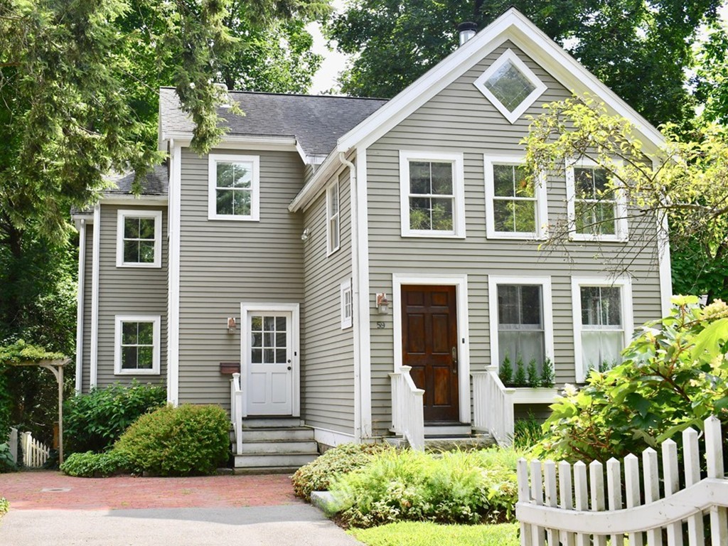 a view of a house with a yard and potted plants