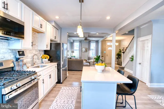a large kitchen with sink a stove and cabinets