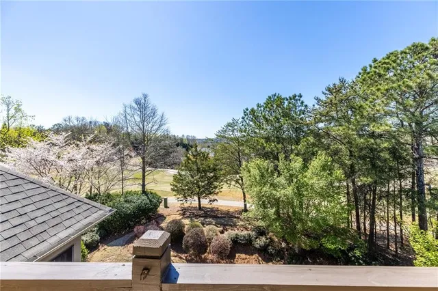 an empty room with a chandelier fan and windows