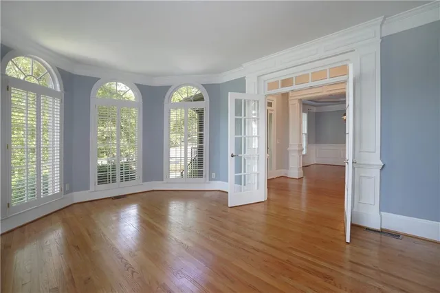 a view of a room with wooden floor chandelier and a window
