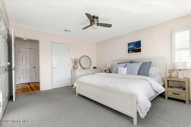 a bed room with a bed and a ceiling fan
