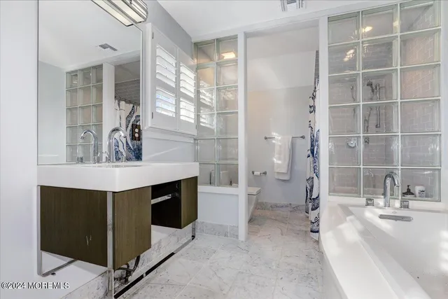 a bathroom with a double vanity sink a mirror and a bathtub