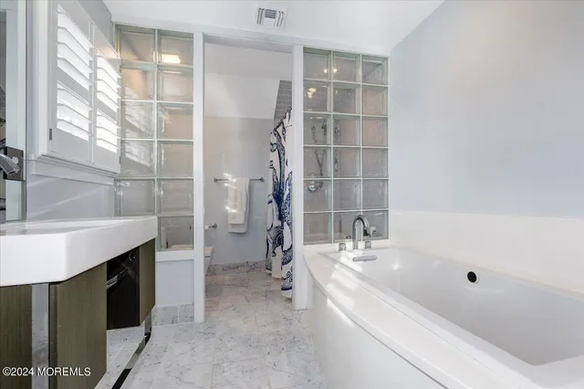 a bathroom with a bathtub and a sink