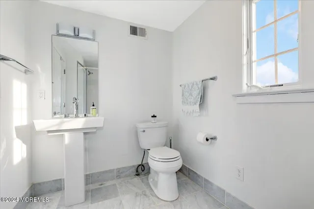 a bathroom with a toilet sink and mirror