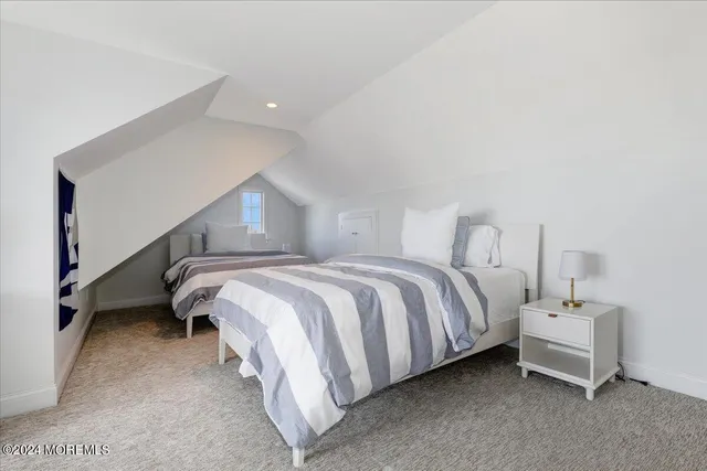 a spacious bedroom with a bed and a lamp