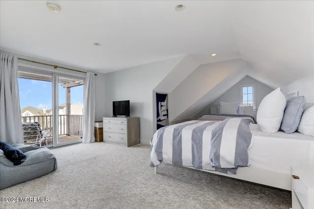 a spacious bedroom with a bed and a flat screen tv