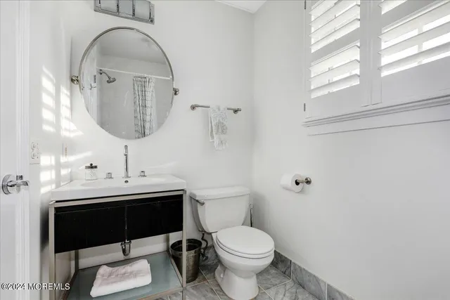 a bathroom with a toilet a sink and mirror