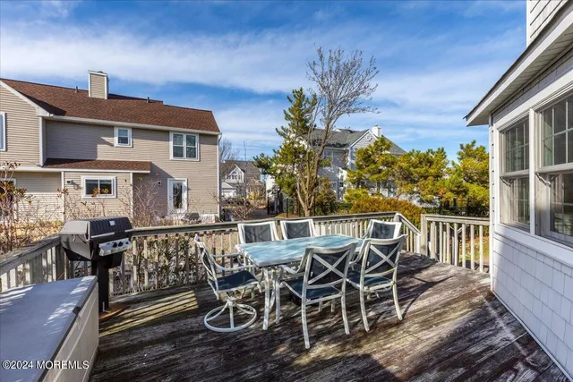 a view of a patio with table and chairs with wooden floor and fence