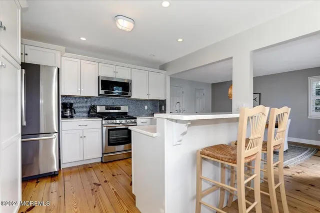 a kitchen with stainless steel appliances granite countertop a refrigerator stove microwave and sink