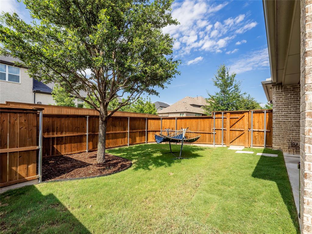 15340 Crape Myrtle Road Frisco, TX 75035 - Photo 39 of 40 Fenced backyard featuring a mature tree, manicured lawn, and stepping stone pathway