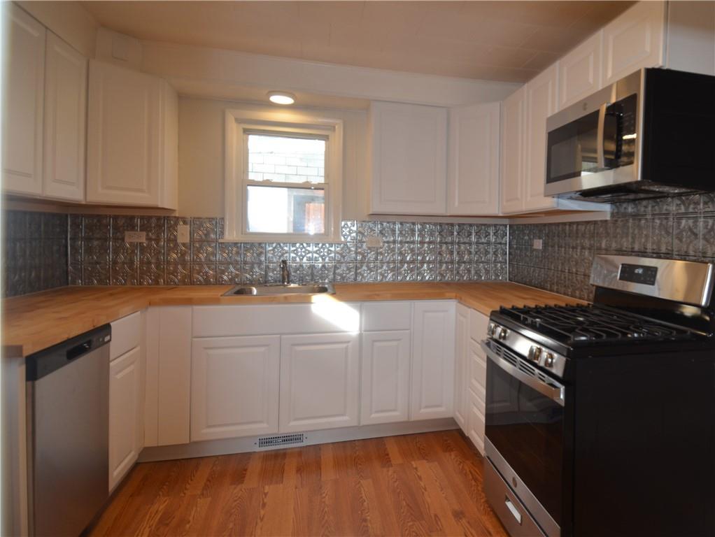 340 Prestley Road Bridgeville, PA 15017 - Photo 12 of 23 a kitchen with granite countertop wooden cabinets and a stove top oven