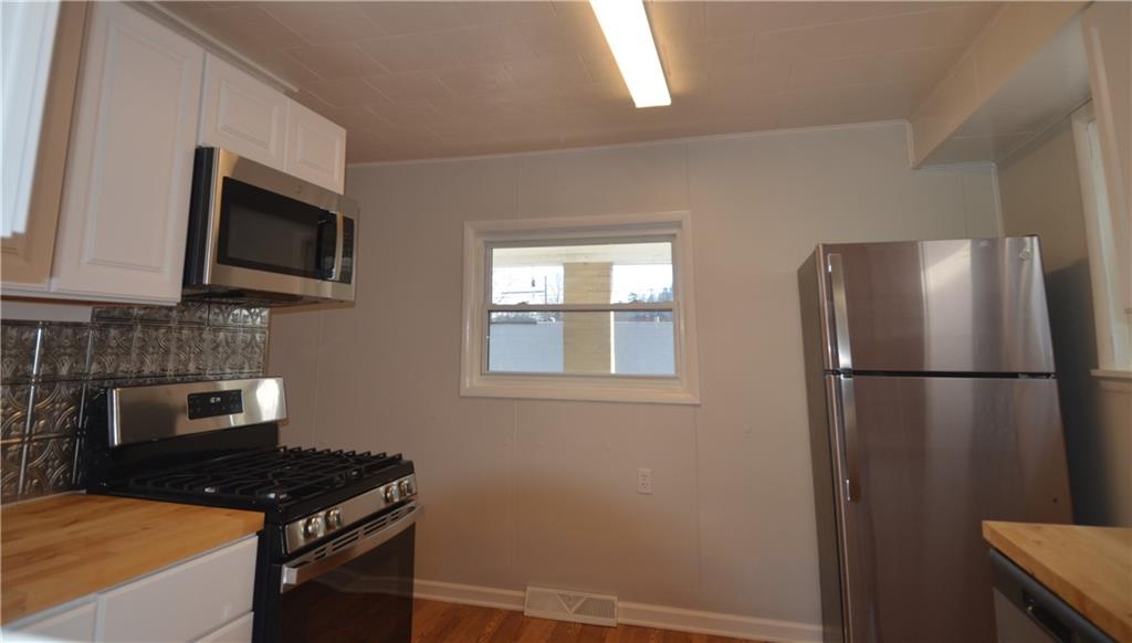 340 Prestley Road Bridgeville, PA 15017 - Photo 13 of 23 a kitchen with a refrigerator and a stove top oven