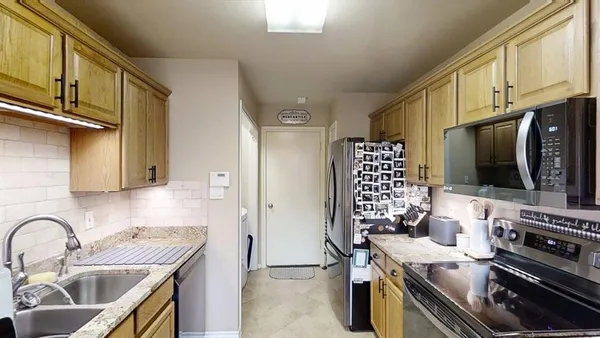 a kitchen with stainless steel appliances a stove a sink a microwave and refrigerator