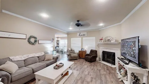 a living room with furniture a fireplace and a flat screen tv