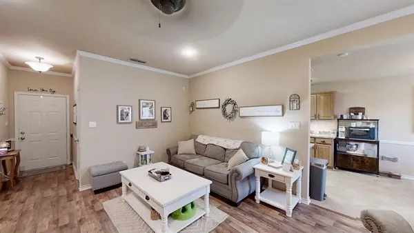 a living room with furniture and a wooden floor