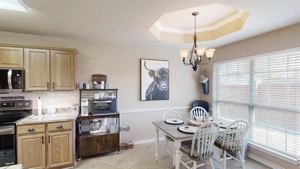 a view of a dining room with furniture and chandelier