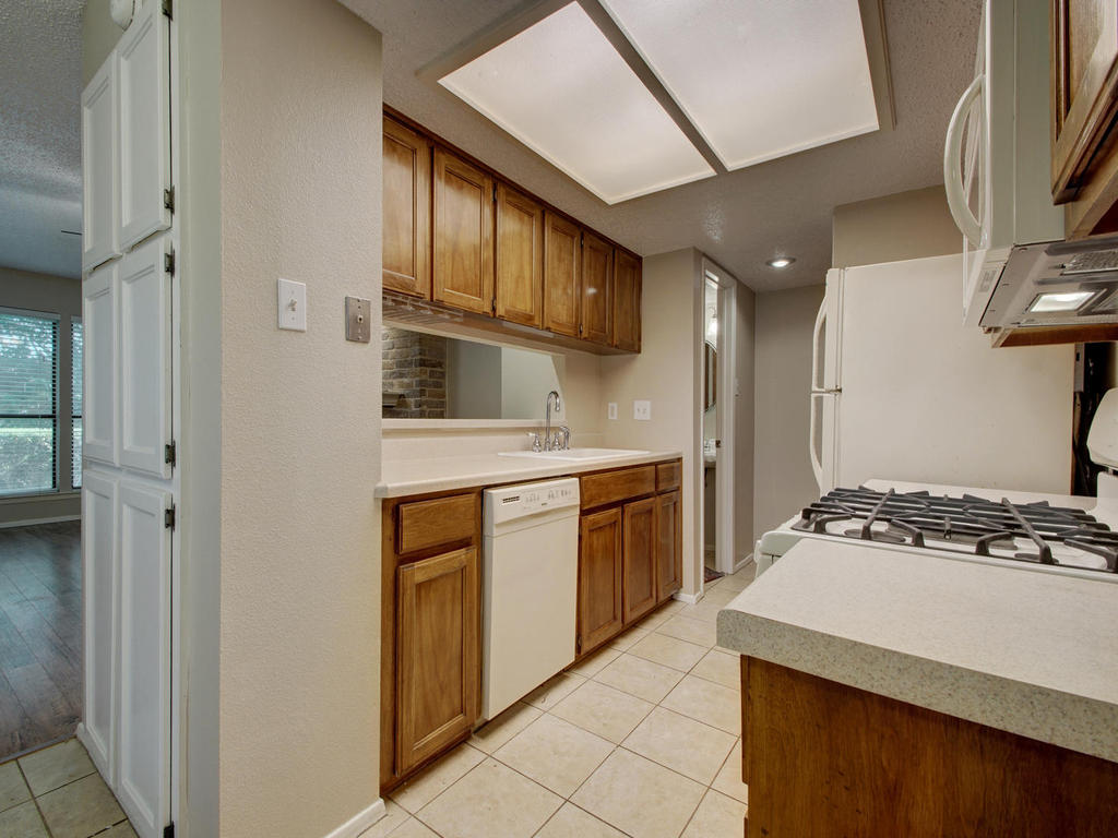 11301 Jollyville Road, Unit A3 Austin, TX 78759 - Photo 12 of 26 a kitchen with stainless steel appliances granite countertop a stove and a refrigerator