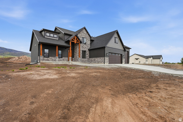 2970 North Mahogany Vly Road Logan, UT 84341 - Photo 2 of 39 Modern farmhouse with stone siding, a garage, covered porch, roof with shingles, and driveway