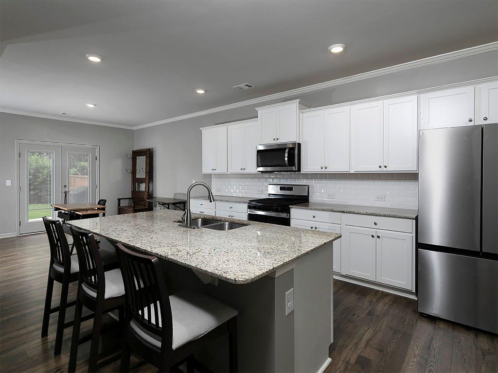 371 Highgrove Circle Dallas, GA 30157 - Photo 2 of 20 a kitchen with a stove a sink a microwave a refrigerator and white cabinets
