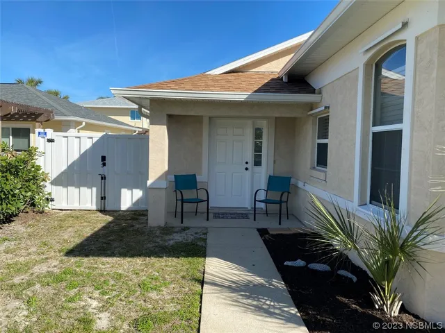 a view of a house with backyard and sitting area